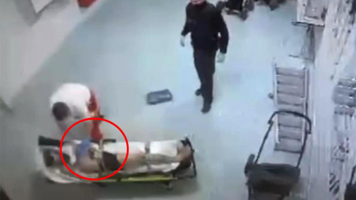 Elleri bağlı sedyede yatan göçmen, ambulans şoförü tarafından darp edildi