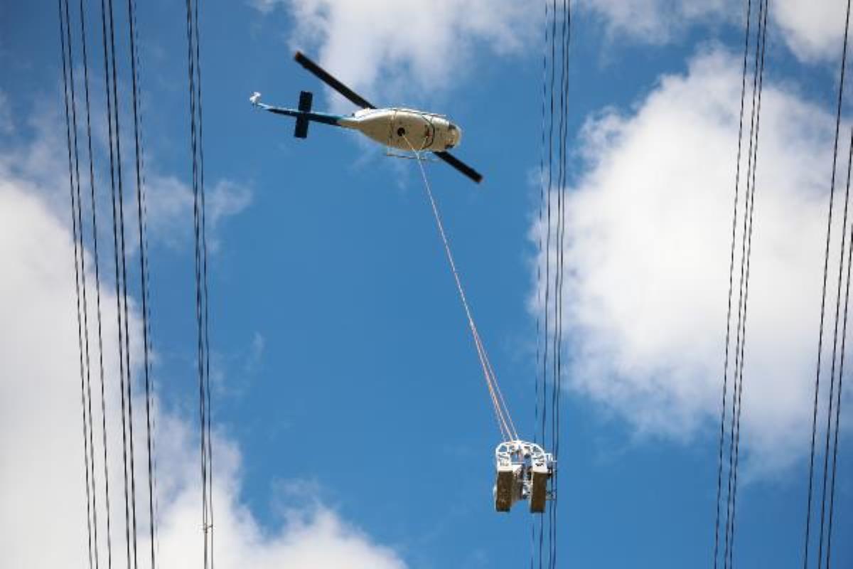 Helikoptere bağlı sepetle elektrik iletim hatlarına bakım yaparken ölüme meydan okuyorlar